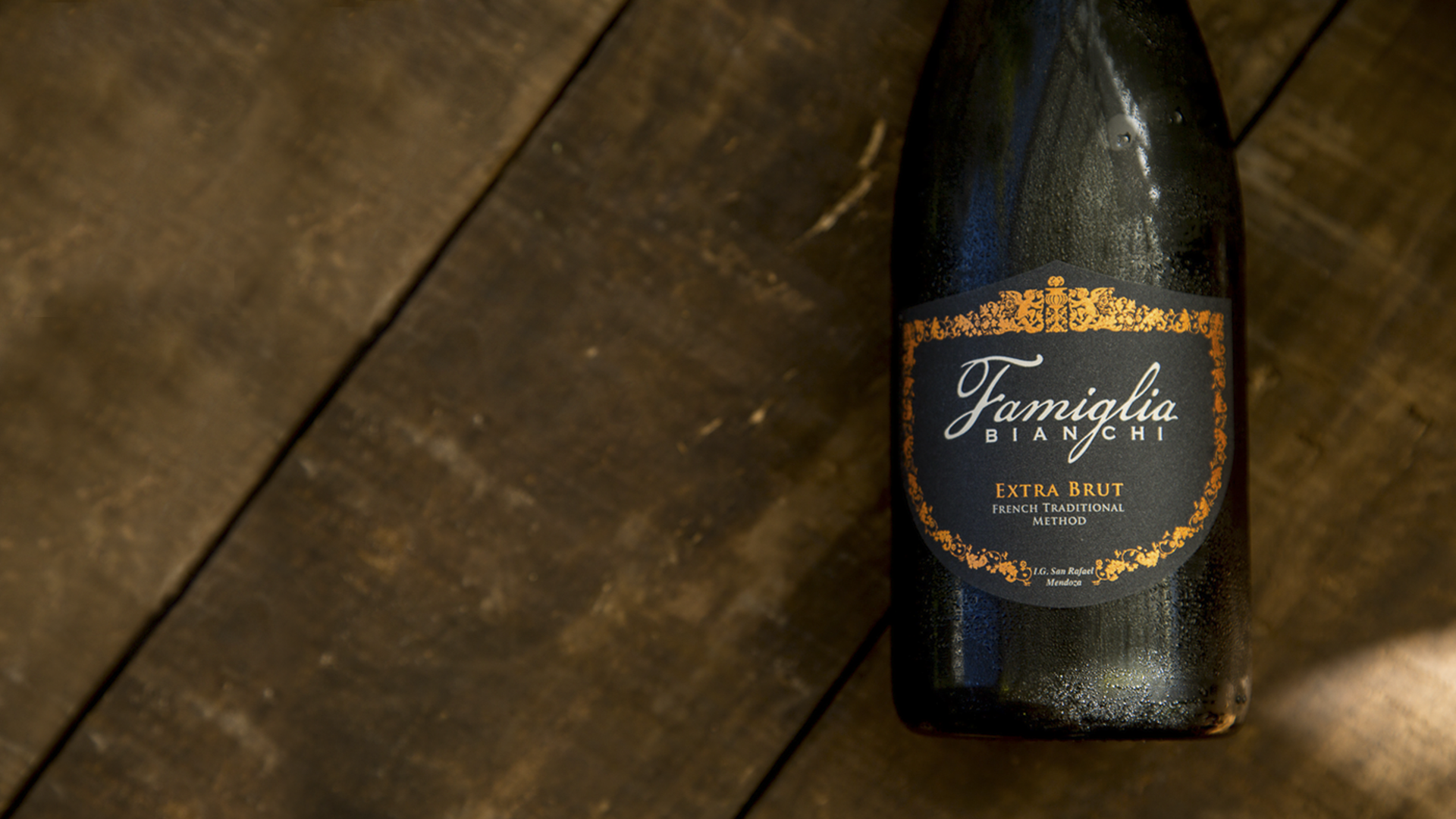 Famiglia Extra Brut bottle over wooden background